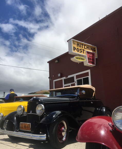 Close up of A line of classic cars parked on a street outside the Hitching Post