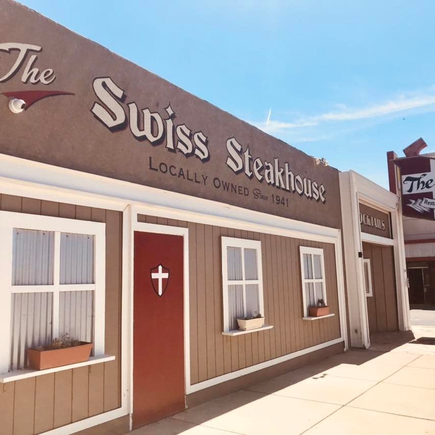 View of the outside of Swiss Steakhouse, where the building reads "The Swiss Steakhouse; Localle owned since 1941"